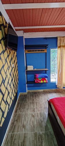 a bedroom with a bed and a blue wall at Finca Campestre Villa del Campo in Santa Rosa de Cabal