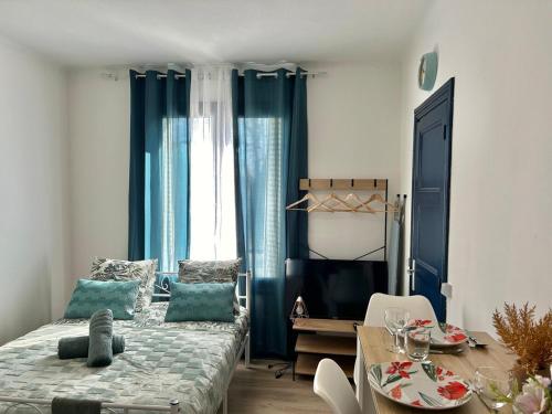 a bedroom with a bed and a table and a dining room at Studio près de la Gare et Centre in Lorient