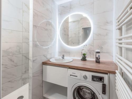 une salle de bain avec une machine à laver et un lavabo dans l'établissement Cour Royale Disneyland Paris, à Chessy