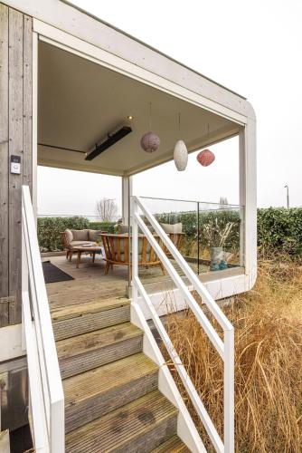 a house with a staircase leading to a deck at Maasparcje ecoLodge K2 Roermond in Roermond