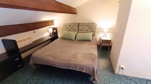 une chambre avec un grand lit et deux tables de nuit dans l'établissement Appartement Barcarès piscine chauffée, au Barcarès