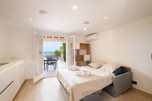 a bedroom with a large bed and a balcony at Mazet design vue mer 4 guests in Sainte-Maxime