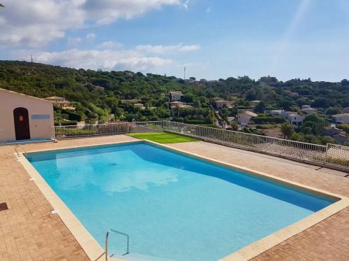 une grande piscine bleue avec une colline en arrière-plan dans l'établissement Mazet design vue mer 4 guests, à Sainte-Maxime