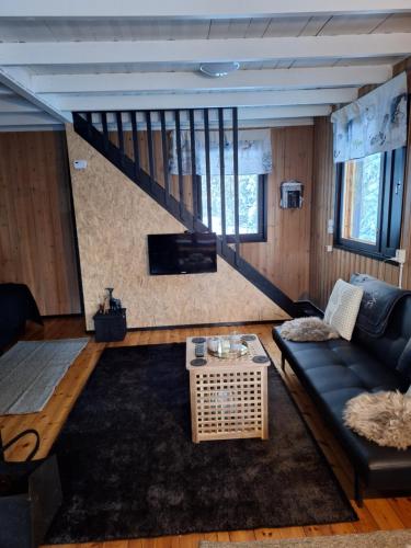 a living room with a couch and a staircase at Lisman Lumo in Kittilä