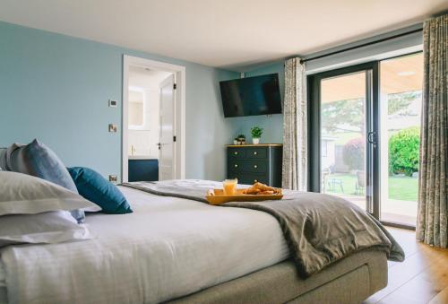 a bedroom with a large bed with a tray of food on it at Heron House in Newquay
