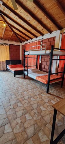 two bunk beds in a room with a stone floor at Finca Campestre Villa del Campo in Santa Rosa de Cabal