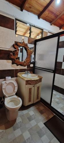 a bathroom with a toilet and a sink at Finca Campestre Villa del Campo in Santa Rosa de Cabal