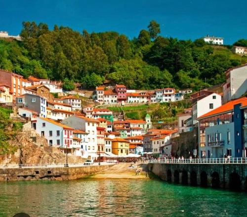 a town on a hill next to a body of water at El mirador de cudillero in Cudillero