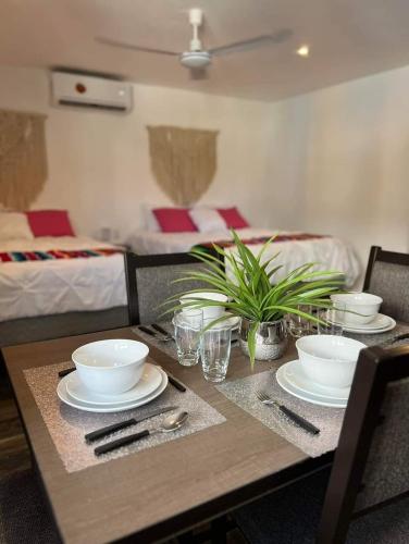 a wooden table with bowls and plates on top of it at Sol de México Apartments in Isla Mujeres