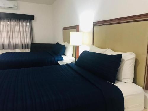 a hotel room with two beds and a couch at Hotel Marina Topolobampo in Topolobampo