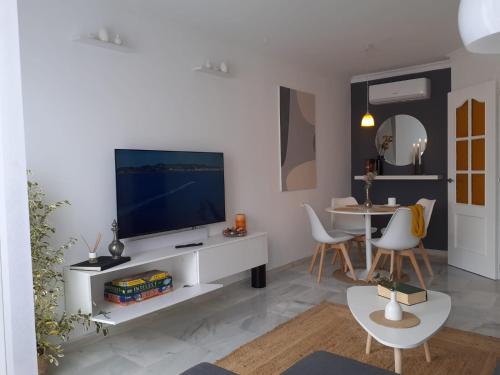 a living room with a television on a white entertainment center at Apartamento Los Naranjos in La Línea de la Concepción