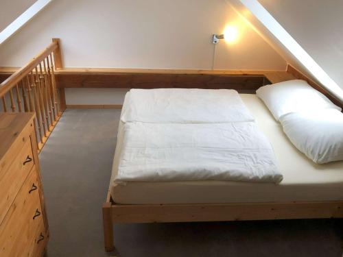 a bed in a room next to a staircase at Braunsberger Höfe - Urlaub auf dem Bauernhof in Braunsberg