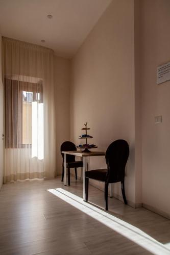 a dining room with a table and chairs and a window at Airport Luxury Rooms in Naples