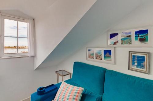 a living room with a blue couch and a window at Seixal Yachting Bay Original in Seixal