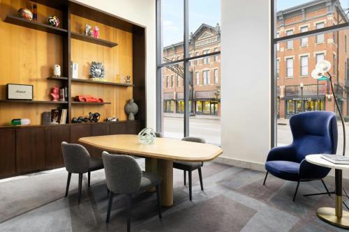 a table and chairs in a room with a window at Le Meridien Columbus, The Joseph in Columbus