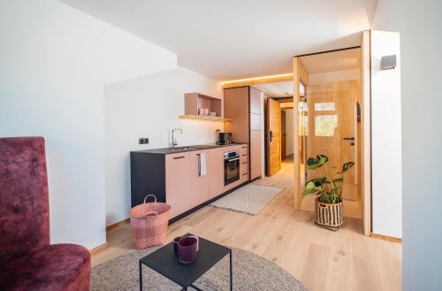 a kitchen and living room with a couch and a table at Neu renovierte Ferienwohnungen im Hotel Hirschentenne in Stams