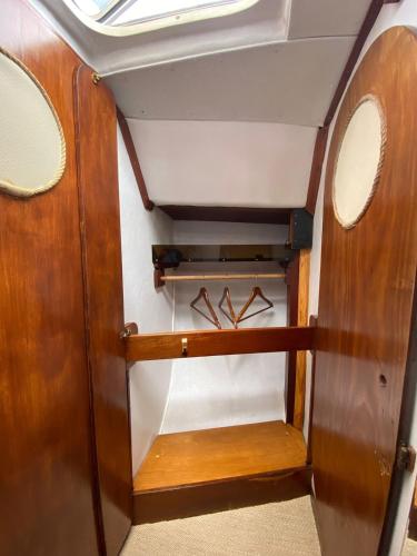 a small room with wooden panels and hangers at Sailboat Anand in Lisbon