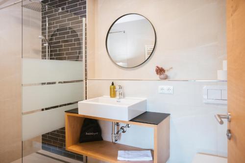 a bathroom with a sink and a mirror at Neu renovierte Ferienwohnungen im Hotel Hirschentenne in Stams