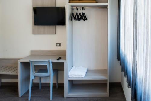 a room with a table and a chair and a desk at Hotel Ariston in Bolzano