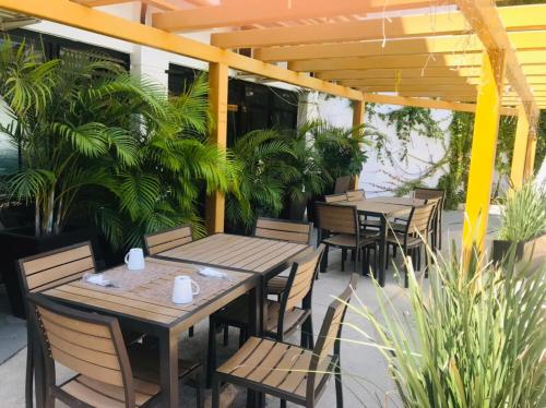 a patio with wooden tables and chairs and plants at Hotel Marina Topolobampo in Topolobampo