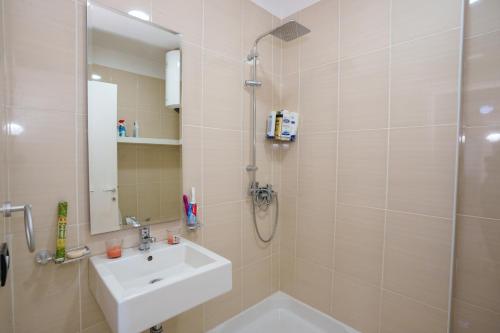 un bagno con doccia, lavandino e doccia di emBrace Apartments a Sarandë