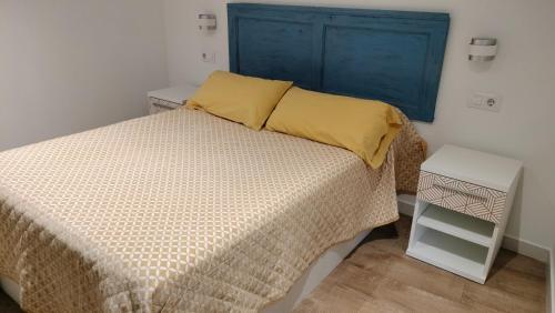 a bedroom with a bed with a blue headboard at Apartamentos Montgò in Denia