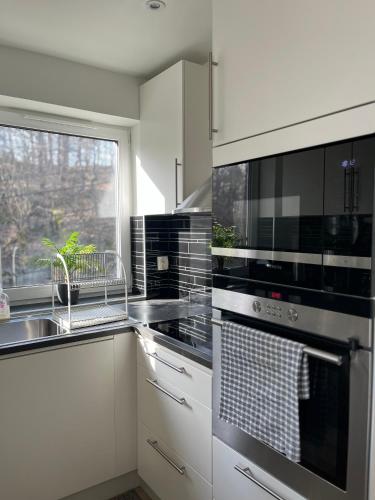 a kitchen with a stove and a sink and a window at Welcome to our new build house! in Landvetter
