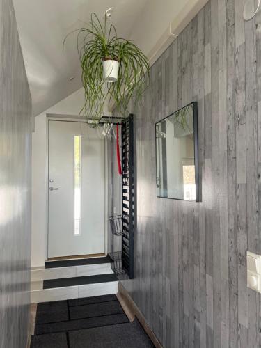 a hallway with a mirror and a potted plant at Welcome to our new build house! in Landvetter