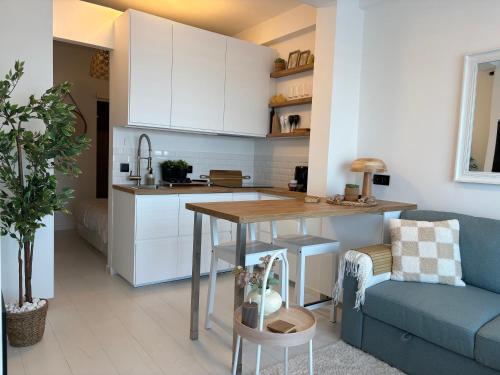 a kitchen and living room with a table and a couch at SEA VIEW Juweeltje in Knokke-Heist