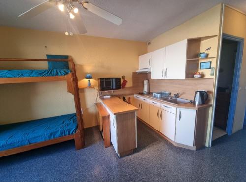 - une petite cuisine avec 2 lits superposés et un évier dans l'établissement PISCINE CHAUFFEE, Vue imprenable Grand studio 4P Coudalère, au Barcarès
