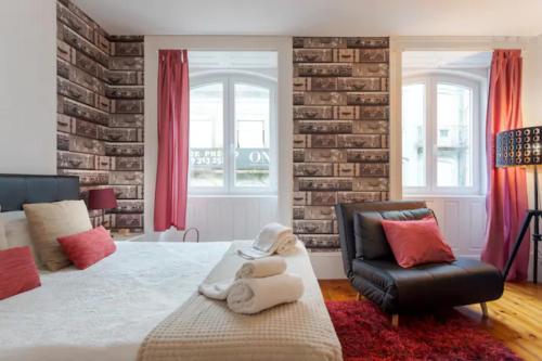 ein Schlafzimmer mit einem großen Bett und einem Stuhl in der Unterkunft Almada e Fado in Porto