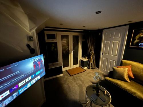 a living room with a couch and a flat screen tv at Aiskew Villa Annex in Bedale