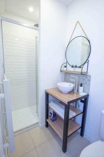 La salle de bains est pourvue d'un lavabo et d'un miroir sur une table. dans l'établissement LE PETIT PRINCE du DESERT, à Moissac