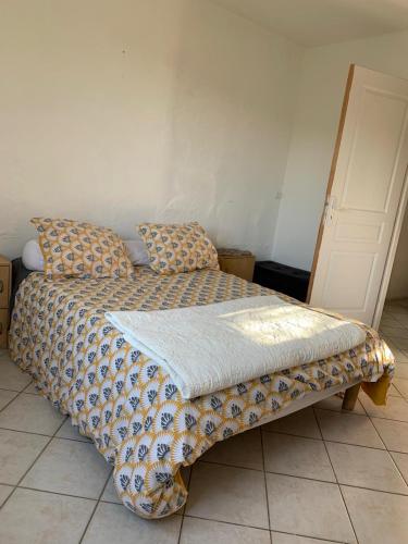 - un lit avec une couverture et des oreillers dans l'établissement PETITE Maison de village Fontienne 21 chemin des charbonniers, à Fontienne