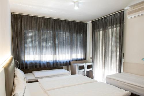 a bedroom with two beds and a window at Hotel Ariston in Bolzano