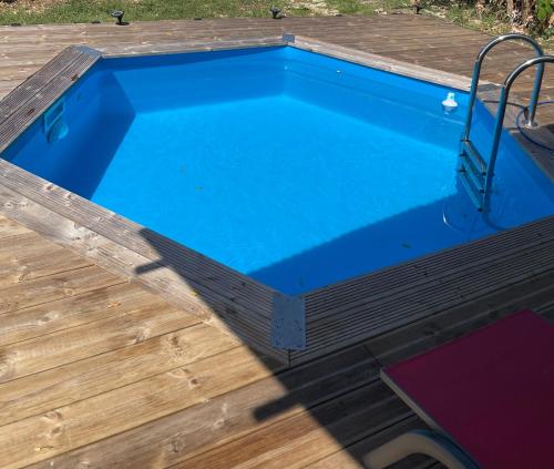 a pool on a wooden deck with a blue swimming pool at Maison Créole in Anse-Bertrand