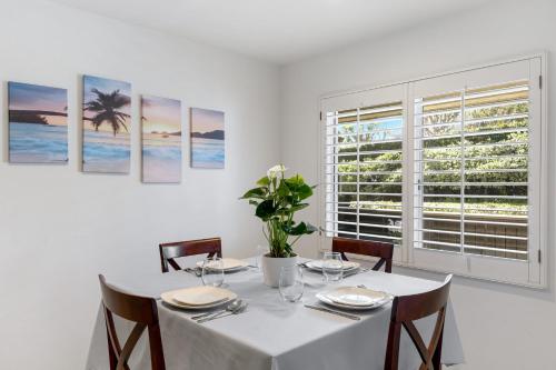 a white dining room with a table and a window at Walk to Beach Pool Hot Tub Private Patio Parking Seabreeze Retreat in Dana Point