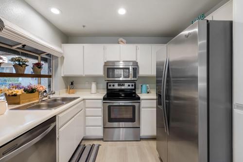 a kitchen with stainless steel appliances and white cabinets at Walk to Beach Pool Hot Tub Private Patio Parking Seabreeze Retreat in Dana Point