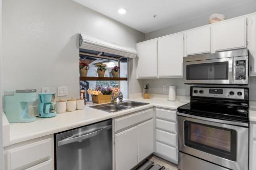 a kitchen with a sink and a microwave at Walk to Beach Pool Hot Tub Private Patio Parking Seabreeze Retreat in Dana Point