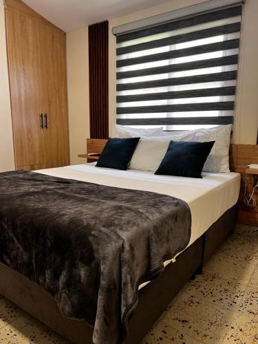 a large bed in a bedroom with a large window at Magiko Suites in Roldanillo