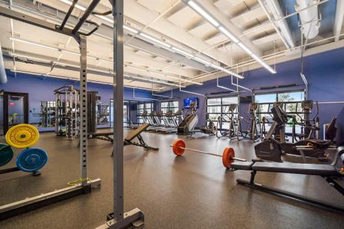 a gym with a lot of equipment in a room at Grand Suite Pinnacle Brownstones in Rogers