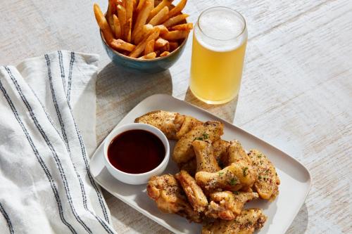 a plate of food with a bowl of fries and a glass of beer at Holiday Inn Little Rock - Presidential Downtown by IHG in Little Rock