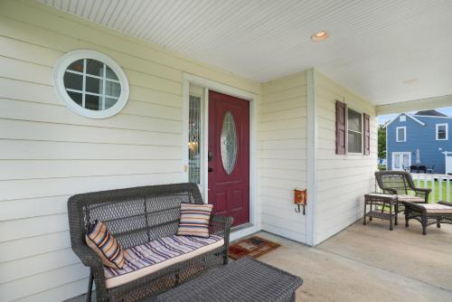 a porch with a bench and a red door at Twins at Bay - Modern luxuries in town! in Cape Charles