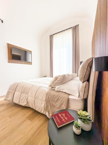 a bedroom with a bed and a table with a book at Bianca Guesthouse in Civitavecchia