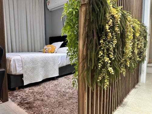 una camera da letto con un letto e un muro di piante di Maravilhoso AP inteiro em frente Hospital Albert Einstein e Estádio Morumbis a San Paolo