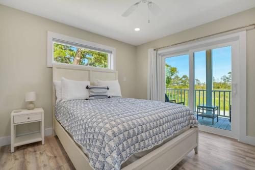 a bedroom with a bed and a window and a balcony at Wildcat Haven - Waterfront & phenomenal views! in Deep Hole