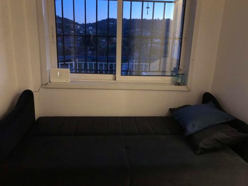 a bed in a room with a window with a laptop at The Sea View Apartment in Oropós