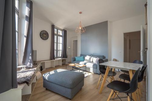un salon avec un canapé et une table dans l'établissement charming city center flat, à Rouen