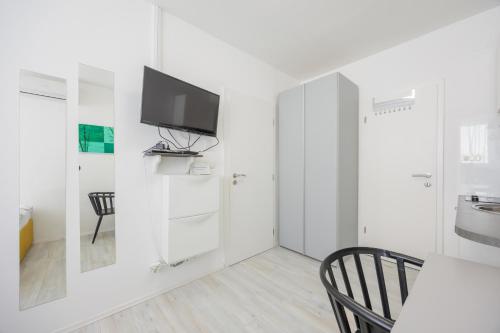 a white room with a tv on a wall at Guest House Arsenal Accommodation in Zadar