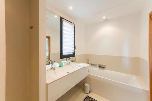 une salle de bain avec un lavabo, une baignoire et un miroir dans l'établissement Superb Villa in Ramatuelle, à Ramatuelle